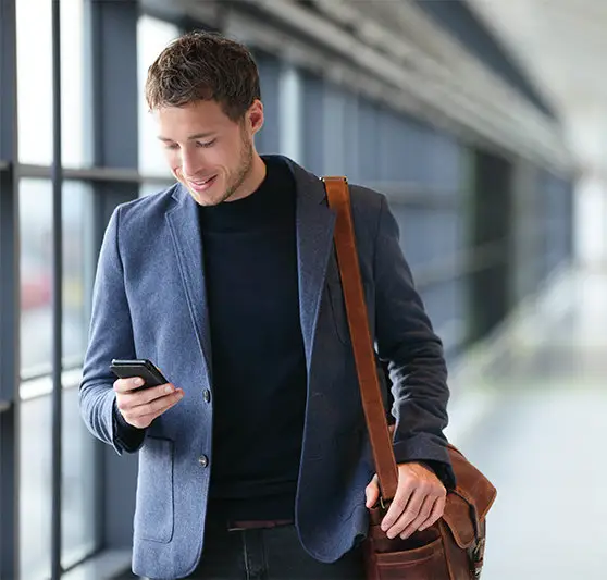 Businessman reading his phone in an airport concourse