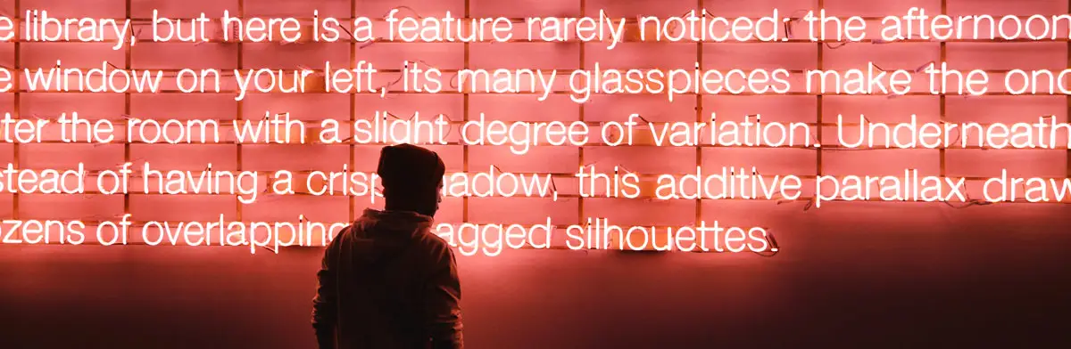 A person silhouetted against a glowing wall of illuminated text